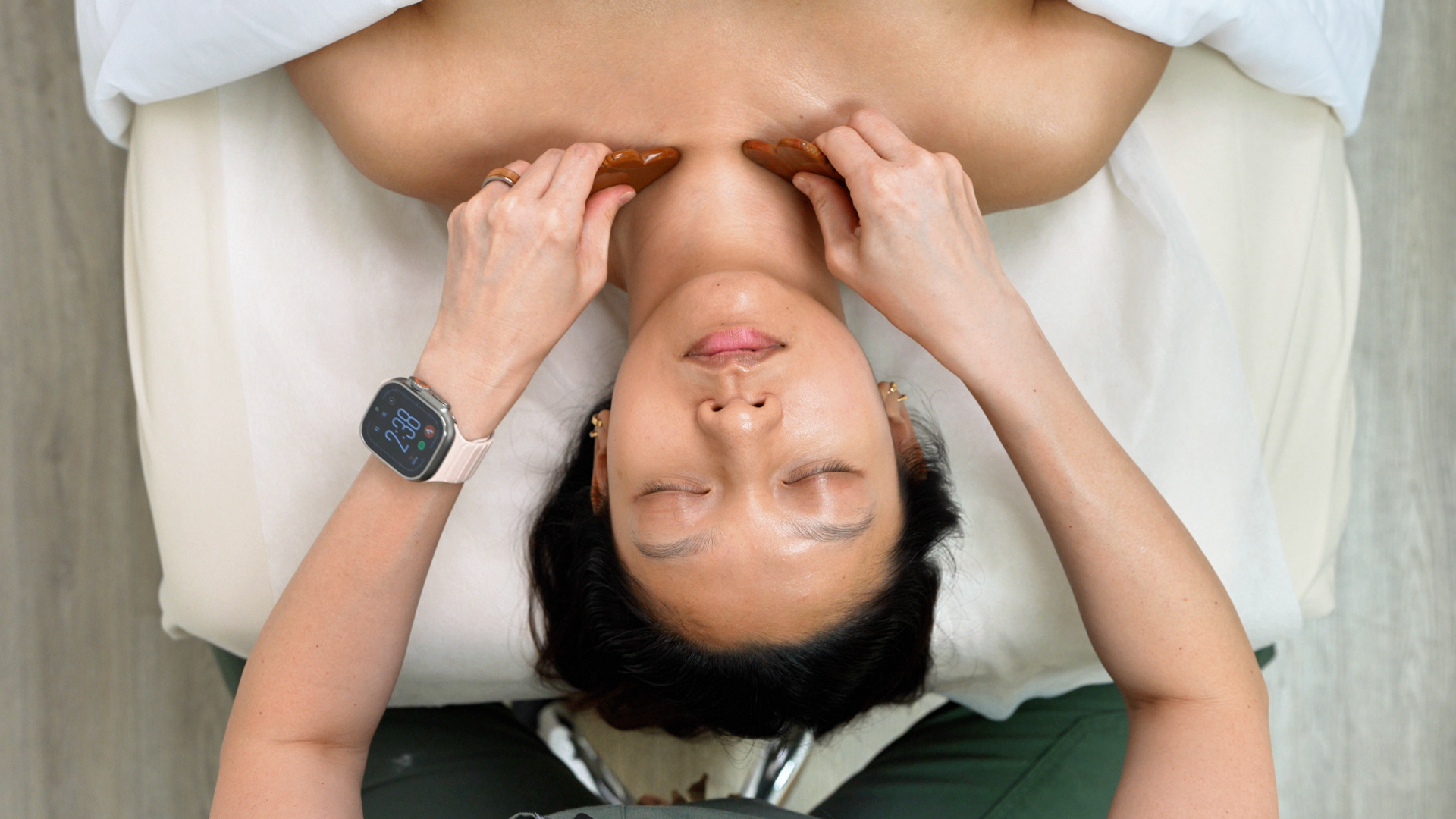 Overhead view of a gua sha facial treatment in progress at The Beauty Within